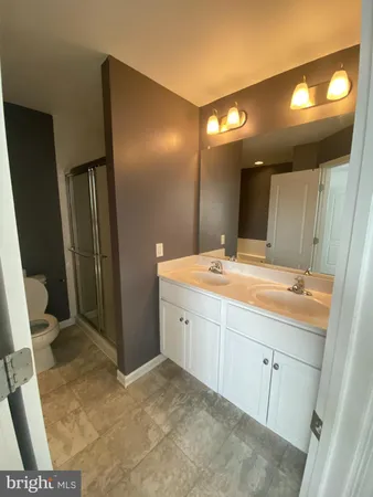 a bathroom with a double vanity sink and a mirror