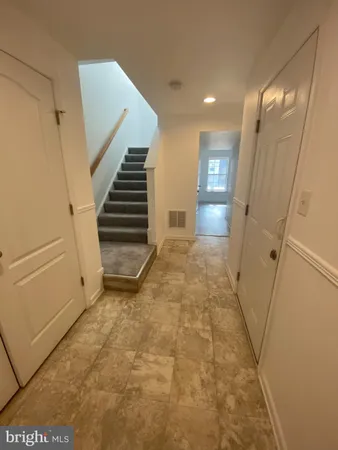 a view of a hallway to rooms and stairs