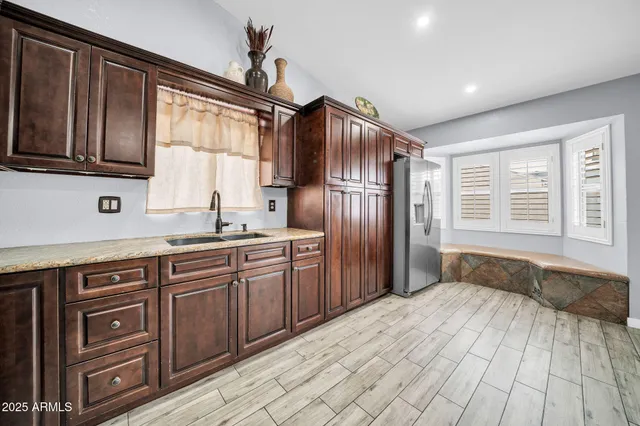 a kitchen with stainless steel appliances granite countertop a refrigerator and a sink