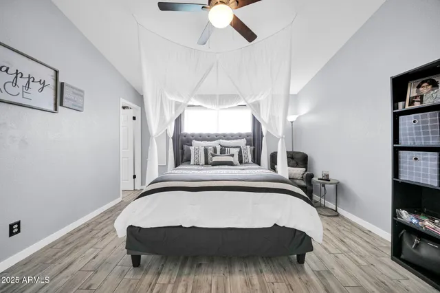 a bedroom with a bed and a flat tv screen on the dresser