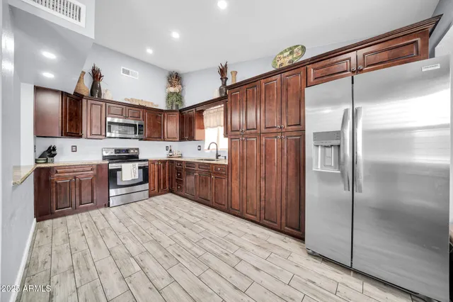 a kitchen with stainless steel appliances granite countertop a refrigerator and a stove