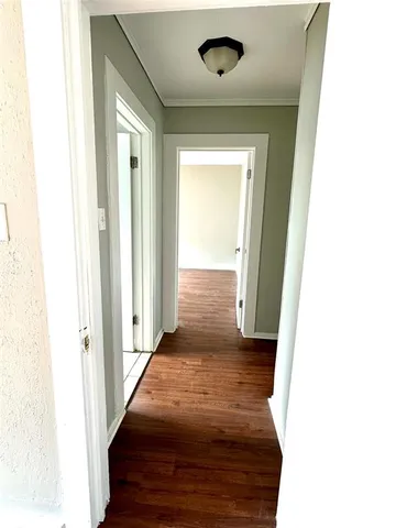 a view of a hallway with wooden floor