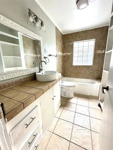 a bathroom with a sink a toilet a mirror and bathtub