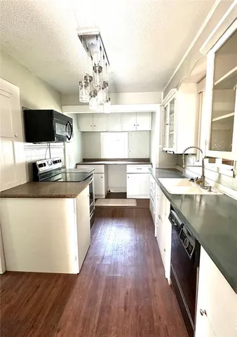 a kitchen with a sink and wooden floor