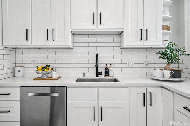 a kitchen with white cabinets and white appliances