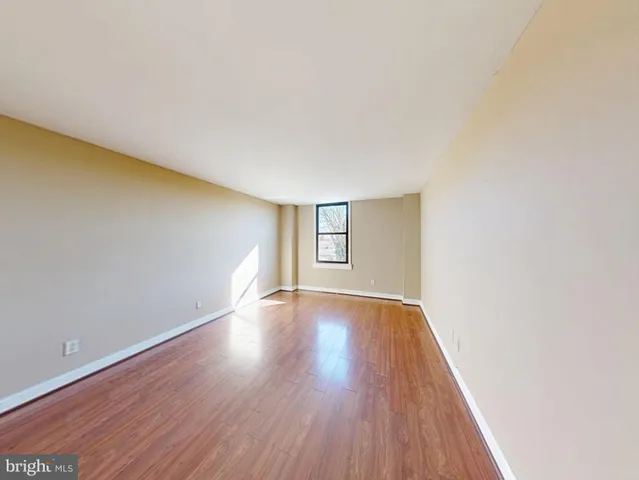 a view of an empty room with wooden and a window