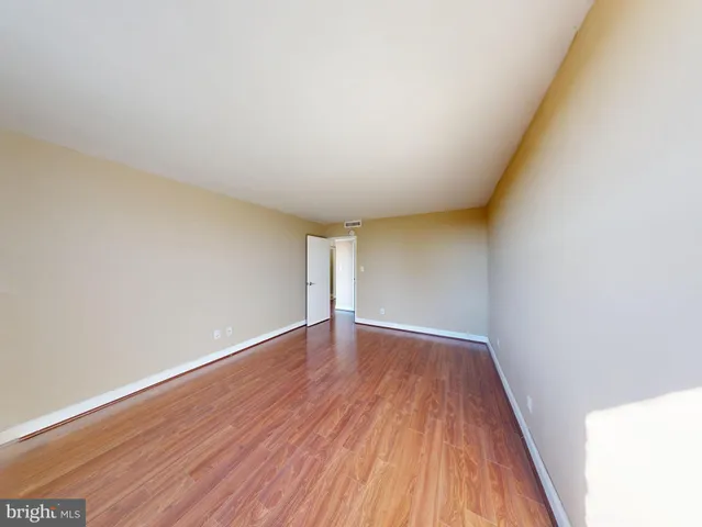 a view of an empty room with wooden floor