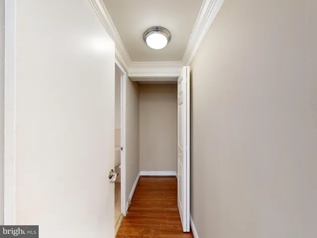 a view of a hallway with wooden floor and closet