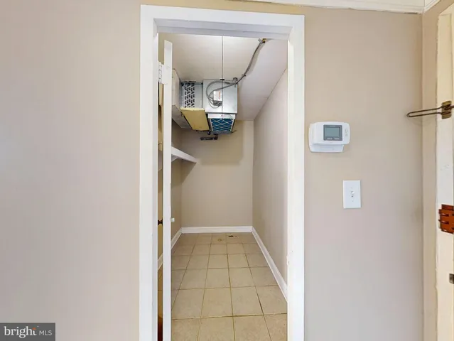 a view of a hallway with wooden floor and a refrigerator