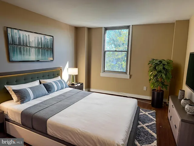 a bedroom with a bed and a potted plant