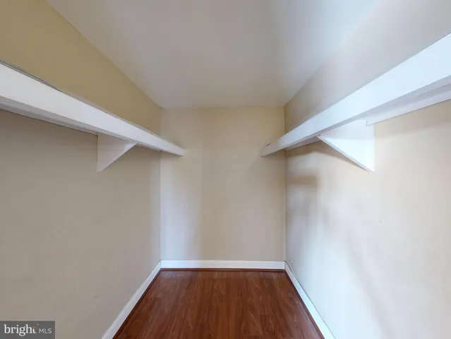 a view of a room with wooden floor and small window