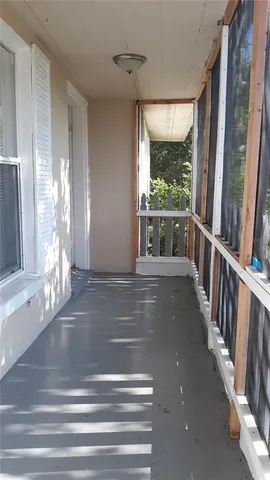 a view of a porch with wooden floor and windows