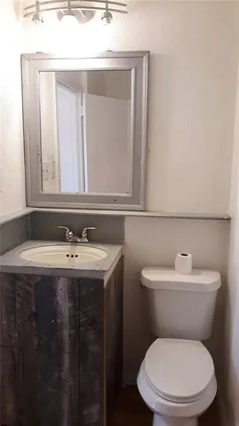 a bathroom with a toilet a sink and mirror