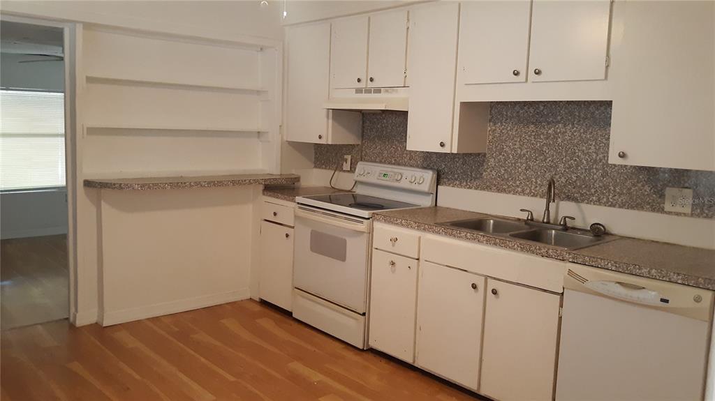 1530 South Martin Luther King Junior Avenue Clearwater, FL 33756 - Photo 8 of 11 a kitchen with granite countertop white cabinets and sink