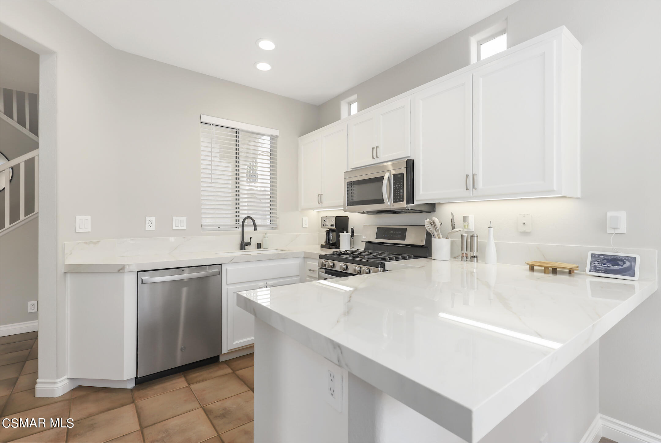 4006 Brindisi Place Moorpark, CA 93021 - Photo 7 of 32 a kitchen with stainless steel appliances a sink a stove a microwave a sink a refrigerator and cabinets