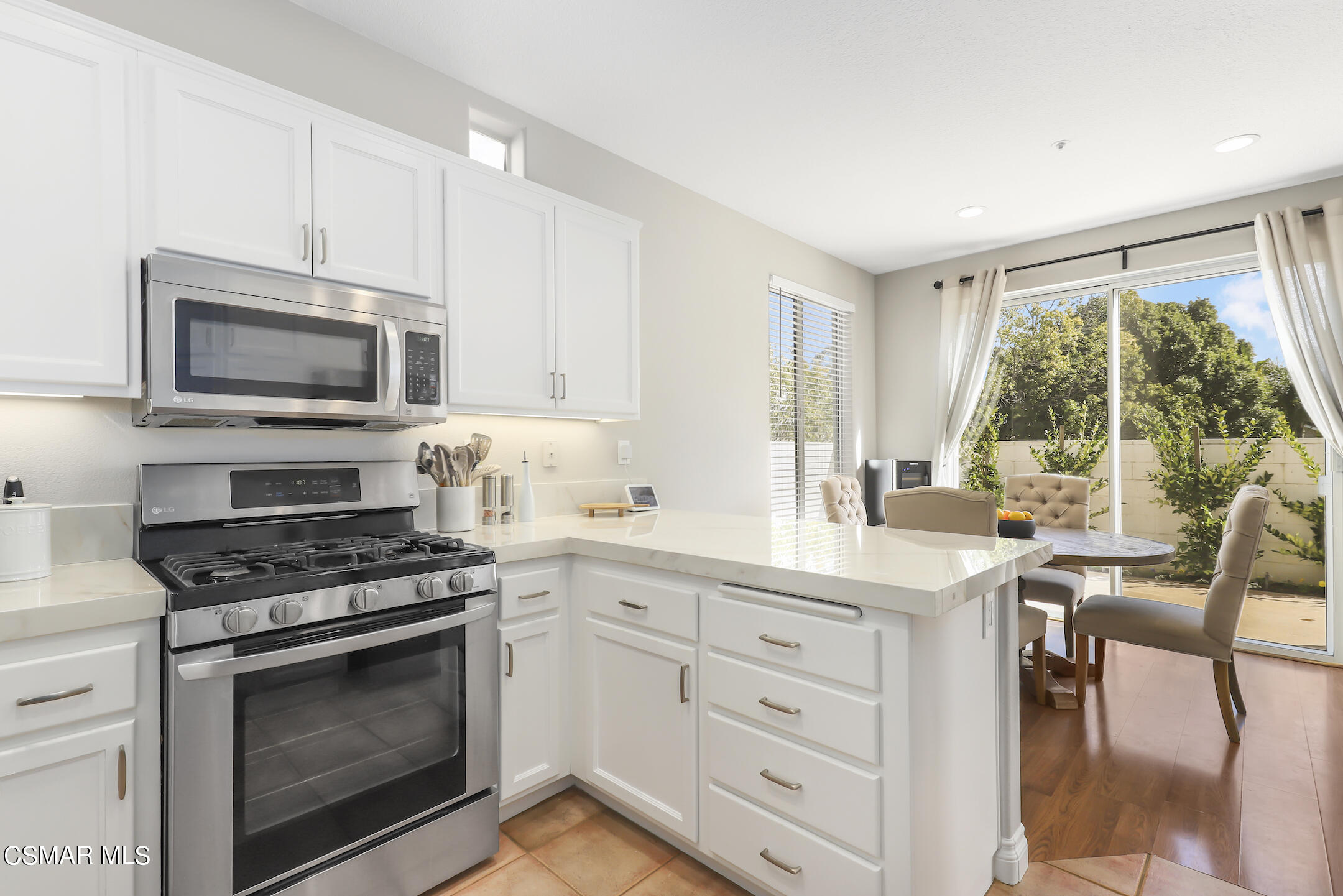 4006 Brindisi Place Moorpark, CA 93021 - Photo 8 of 32 a kitchen with white cabinets stainless steel appliances and a window