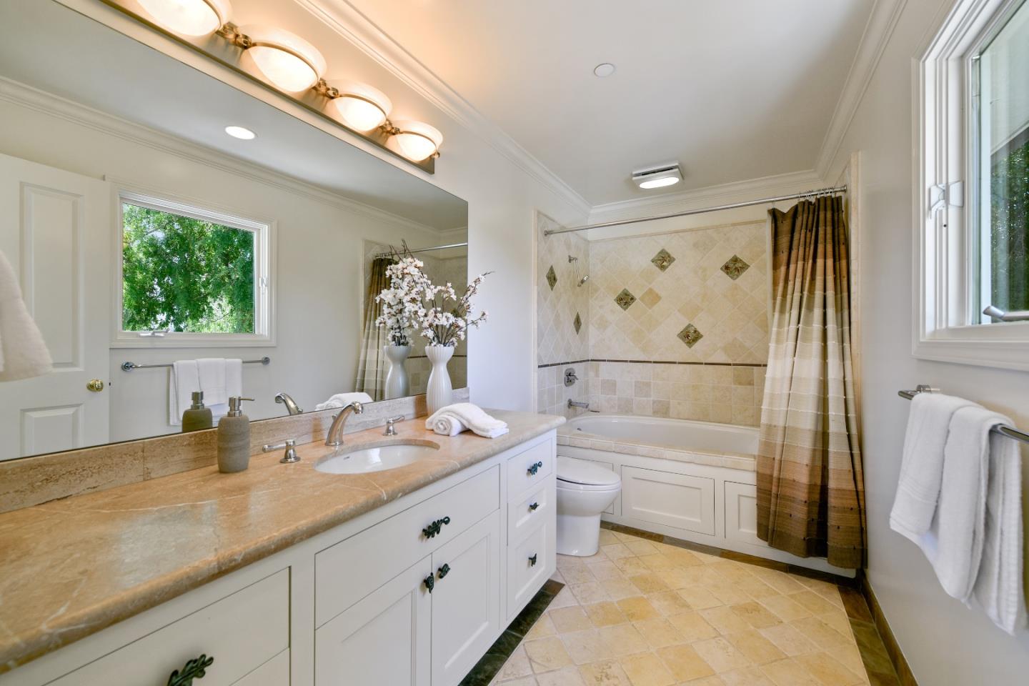 855 Longview Road Hillsborough, CA 94010 - Photo 18 of 32 a bathroom with a double vanity sink a mirror a bathtub and shower