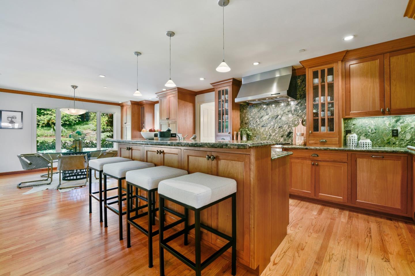 855 Longview Road Hillsborough, CA 94010 - Photo 10 of 32 a kitchen with stainless steel appliances granite countertop table chairs stove and wooden floor