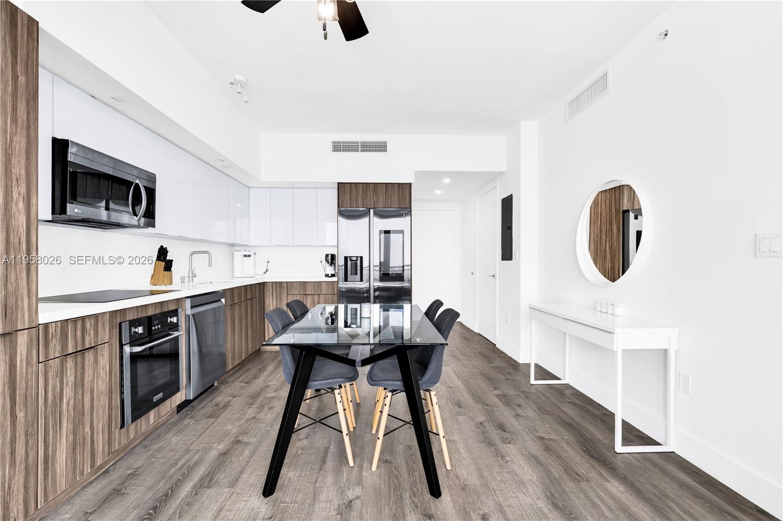 92 Southwest 3rd Street, Unit 3108 Miami, FL 33130 - Photo 6 of 19 a kitchen with stainless steel appliances kitchen island hardwood floor sink stove and microwave