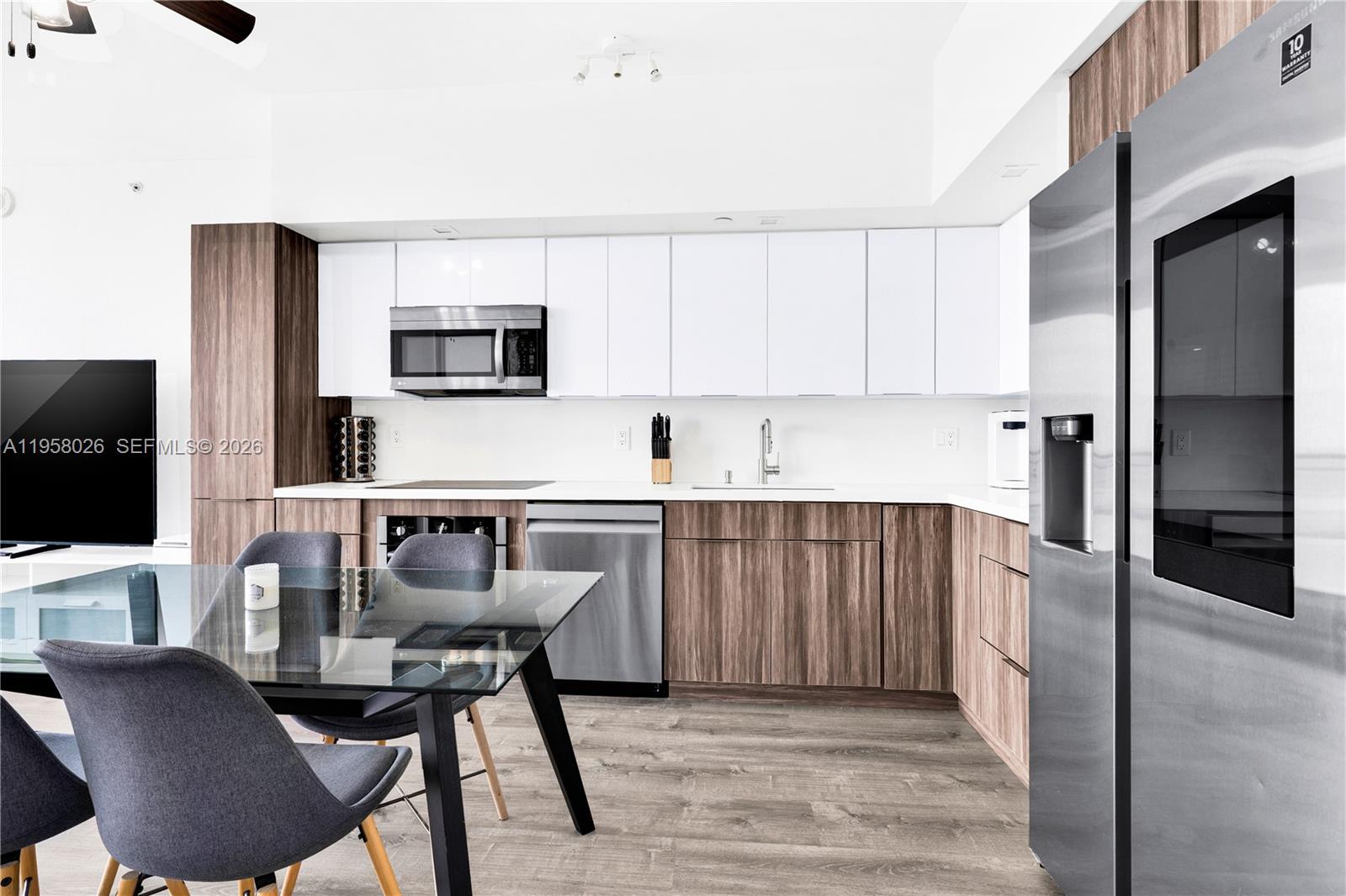 92 Southwest 3rd Street, Unit 3108 Miami, FL 33130 - Photo 9 of 19 a kitchen with stainless steel appliances granite countertop a stove top oven a sink a dining table and chairs