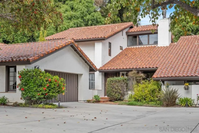 a aerial view of a house with a yard and potted plants