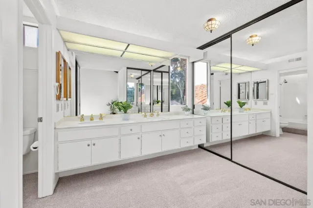 a spacious bathroom with a double vanity sink shower and a mirror