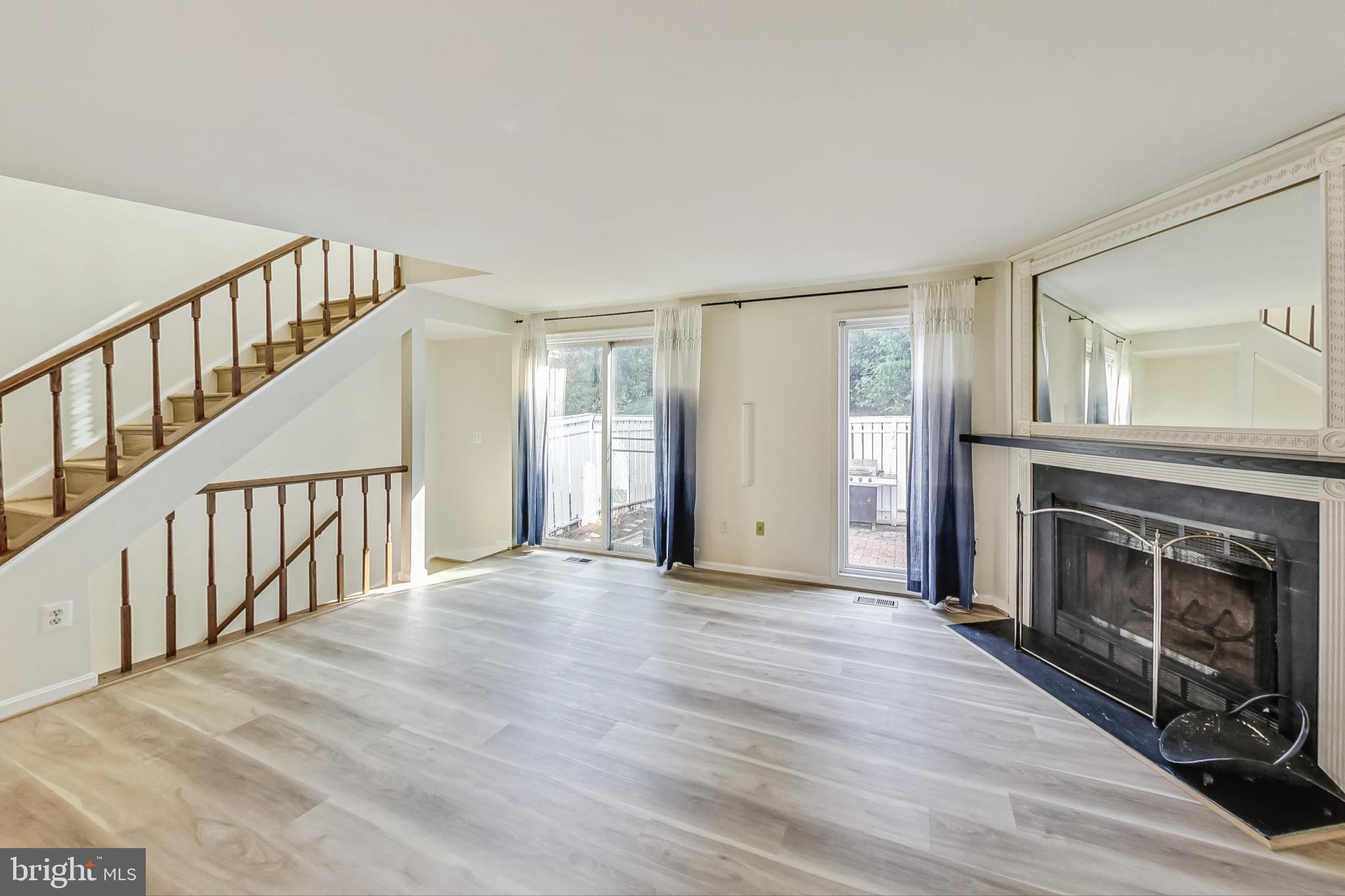 11924 Redtree Way Reston, VA 20194 - Photo 6 of 31 a view of an empty room with wooden floor fireplace and a window