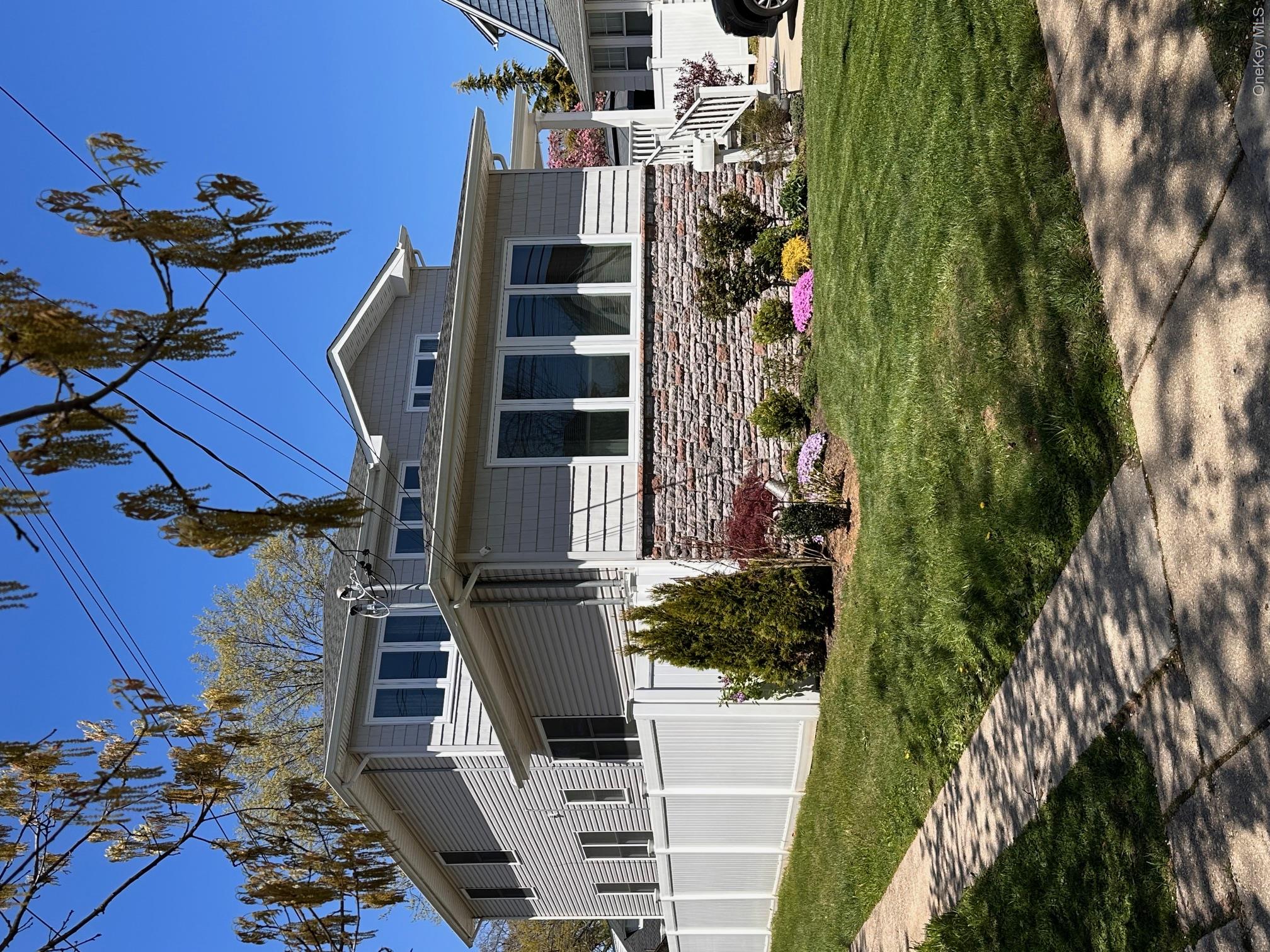 84 Commonwealth Avenue Merrick, NY 11566 - Photo 2 of 6 a front view of a house with a yard