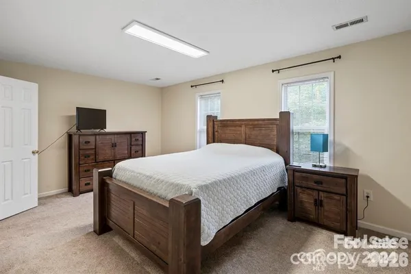 a bed sitting in a bedroom and a tv in a room