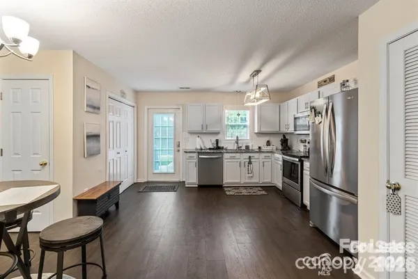 a kitchen with stainless steel appliances a refrigerator a stove a sink dishwasher and a refrigerator with wooden floor