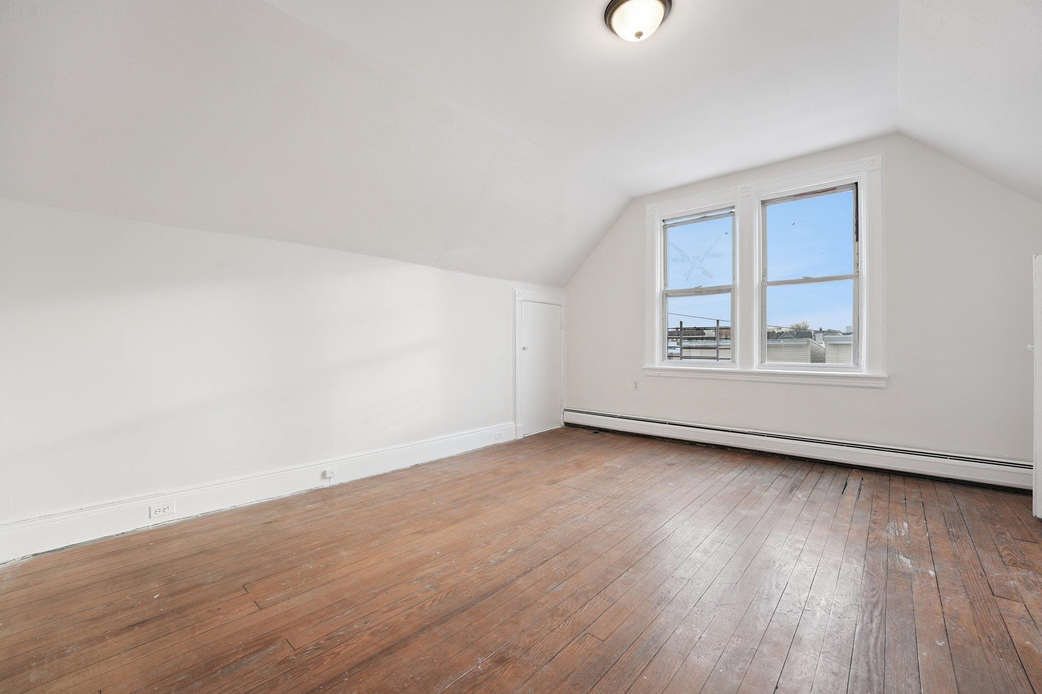 910 19th Street Union City, NJ 07087 - Photo 16 of 30 an empty room with wooden floor and windows