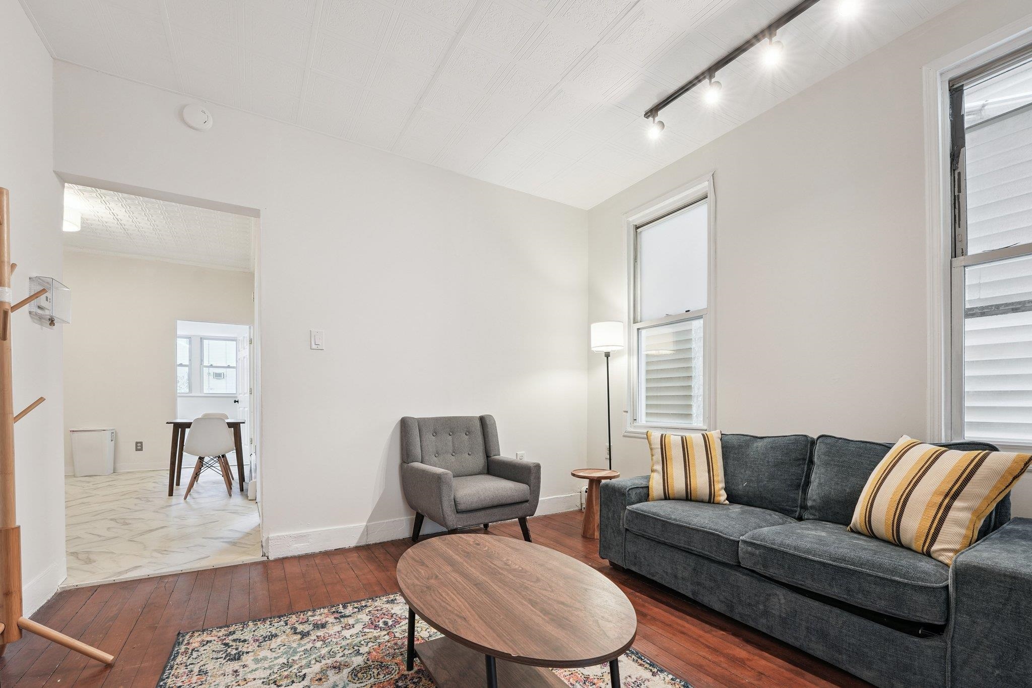 910 19th Street Union City, NJ 07087 - Photo 30 of 30 a living room with furniture a rug a lamp and a window