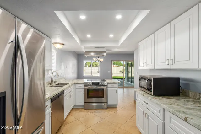 a kitchen with stainless steel appliances granite countertop a stove a sink and a refrigerator
