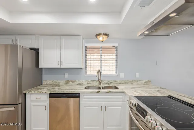 a kitchen with granite countertop a sink stove and cabinets
