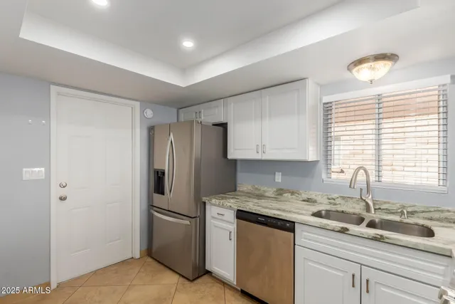 a kitchen with stainless steel appliances granite countertop a stove a sink and a refrigerator