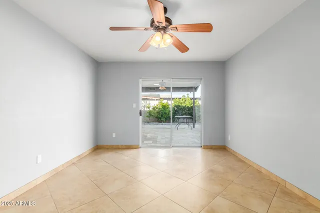 an empty room with windows and a ceiling fan
