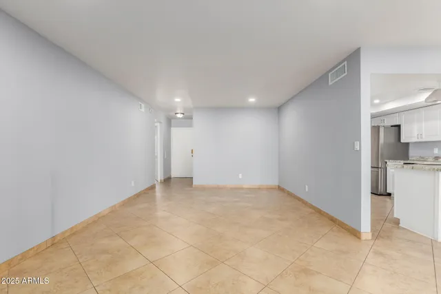 a view of an empty room with kitchen