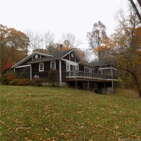 a view of a house with pool and wooden fence