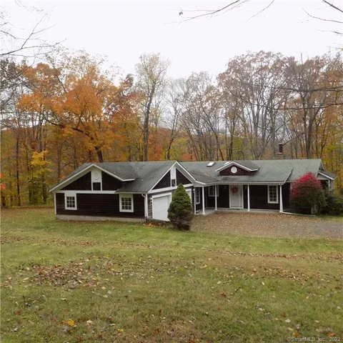 a view of a house with a yard and sitting area
