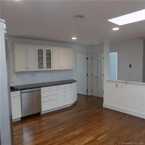 a kitchen with wooden floors and white cabinets