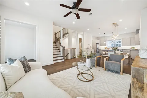a living room with furniture a kitchen view and a chandelier