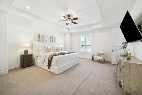 a bedroom with bed tv and window