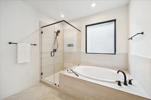 a spacious bathroom with a tub and a shower
