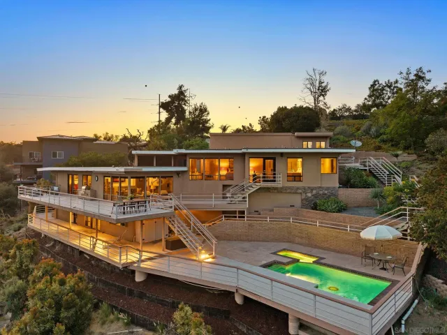 a view of a house with pool and chairs
