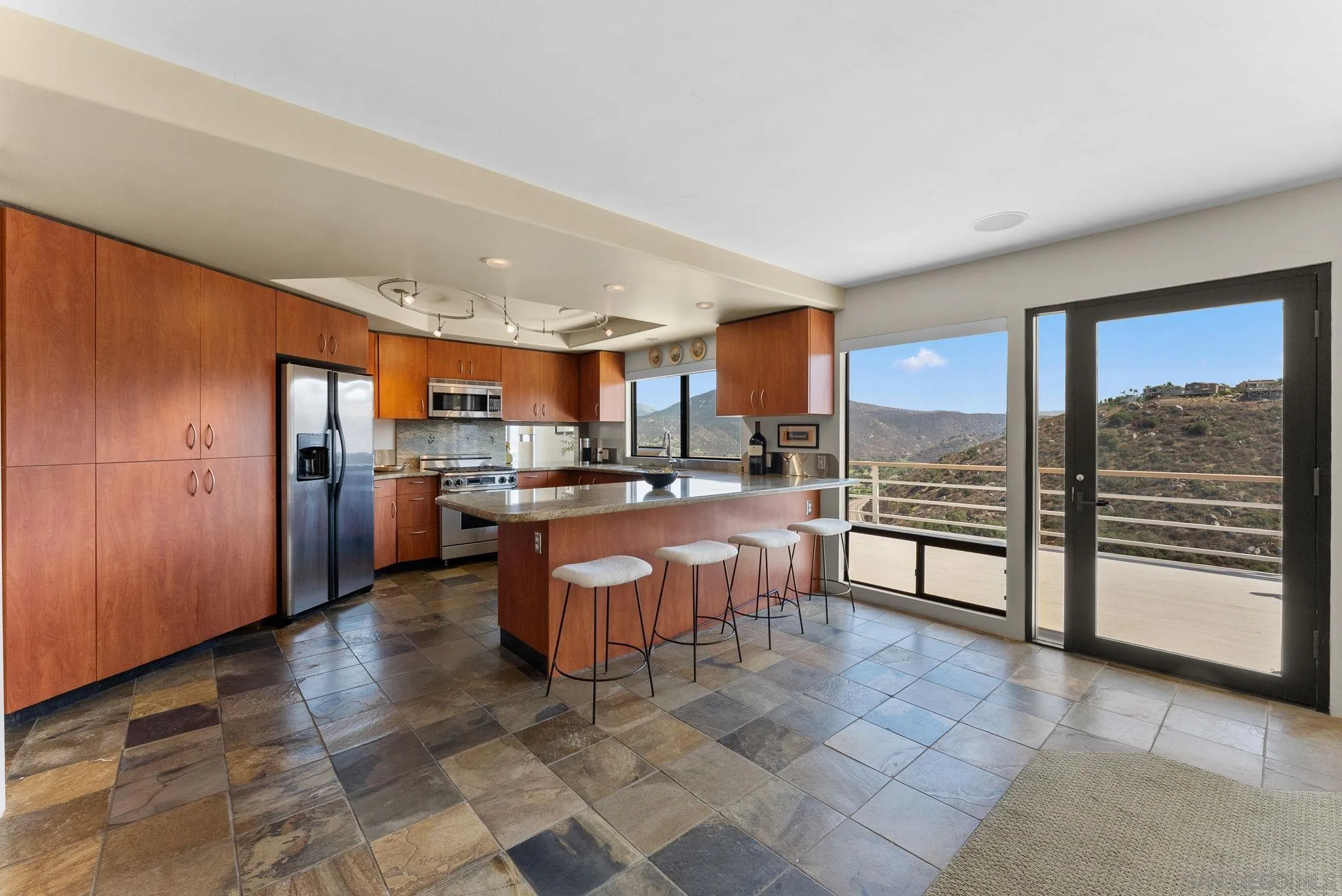 2552 Singing Vista Way El Cajon, CA 92019 - Photo 17 of 34 a open kitchen with stainless steel appliances granite countertop a refrigerator stove top oven and a sink with granite countertops