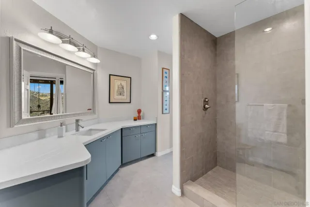 a bathroom with a double vanity sink mirror and shower