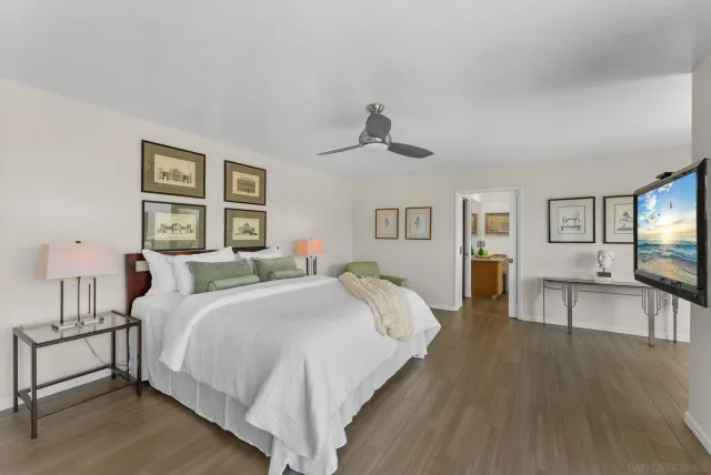 a bedroom with a large bed a chandelier and dresser