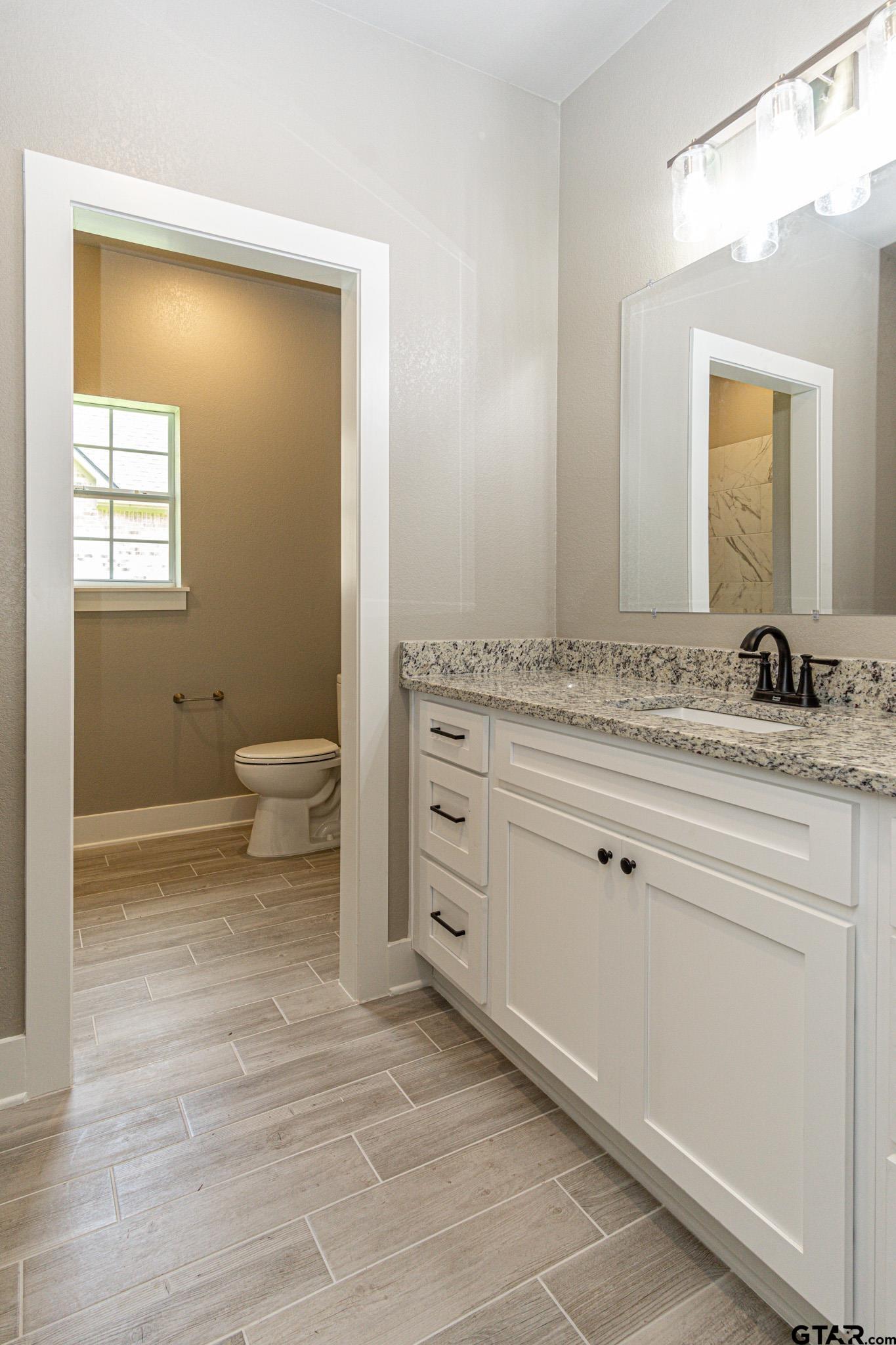 122 Pr 6305 Mineola Tx 75773 Mineola, TX 75773 - Photo 21 of 28 a bathroom with a granite countertop sink toilet and mirror