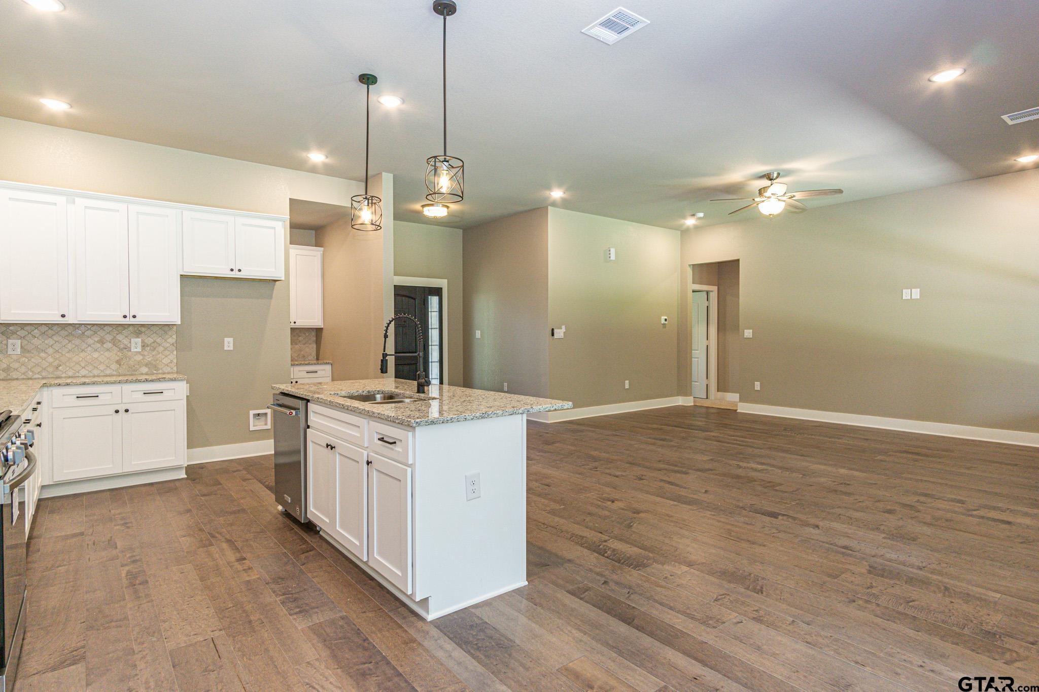 122 Pr 6305 Mineola Tx 75773 Mineola, TX 75773 - Photo 4 of 28 a large kitchen with granite countertop a stove a sink a center island and wooden floor