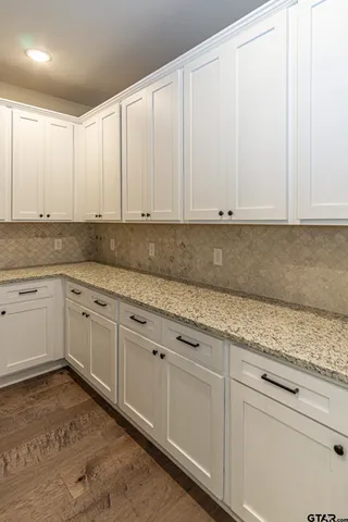 a kitchen with granite countertop white cabinets and white appliances